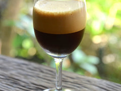 Caffè shakerato w kieliszku na nóżce z gęstą kawową pianką