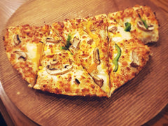 Zapieczone calzone - włoska pizza składana na pół, pokrojona na desce