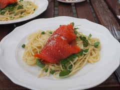 Makaron linguine z wędzonym łososiem i groszkiem na białym talerzu
