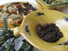 Tapenade z czarnych oliwek w prowansalskiej misce z grzankami i gałązką oliwną