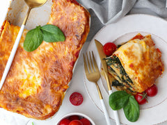 Porcja zapieczonej lasagne z sosem bolognese i beszamelem na talerzu