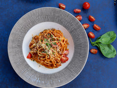 Talerz spaghetti alla puttanesca w sosie pomidorowym z pomidorkami koktajlowymi