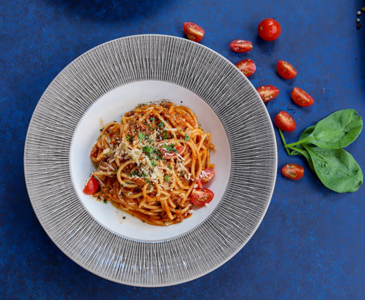 Talerz spaghetti alla puttanesca w sosie pomidorowym z pomidorkami koktajlowymi