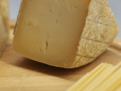Klin dojrzewającego sera parmezan Parmigiano Reggiano z makaronem spaghetti