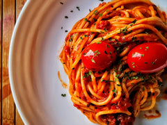 Spaghetti bolognese z sosem mięsnym posypane parmezanem na talerzu