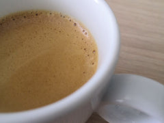 Filiżanka włoskiego espresso z gęstą cremą na drewnianym blacie