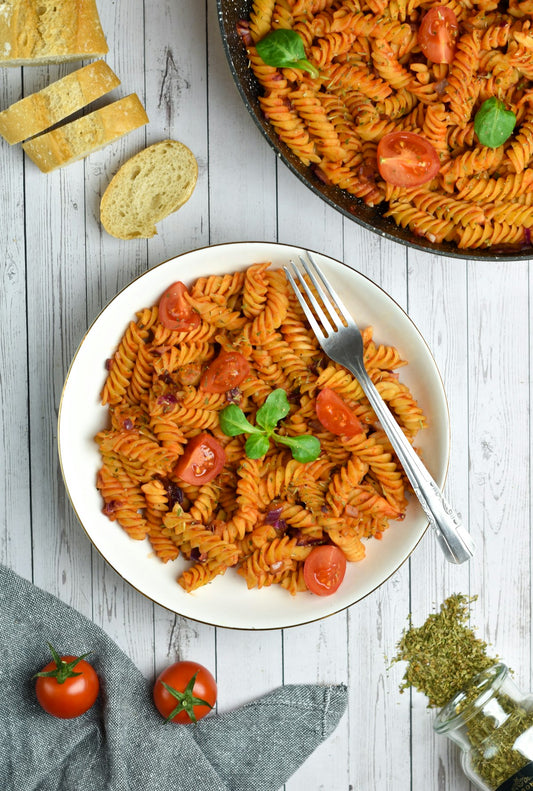 Makaron fusilli z tuńczykiem w sosie pomidorowym na białym talerzu