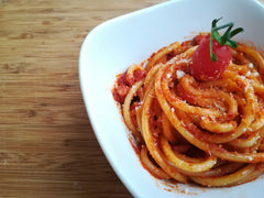 Bucatini all'amatriciana w białej misce - makaron w sosie pomidorowym z kostkami guanciale i startym pecorino