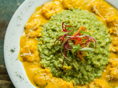 Kremowe risotto z dynią posypane startym serem na talerzu