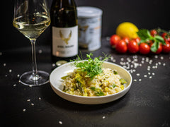 Kremowe risotto z kurczakiem na talerzu z winem i ryżem arborio