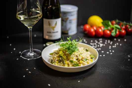 Kremowe risotto z kurczakiem na talerzu z winem i ryżem arborio
