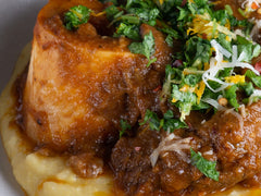 Kremowa polenta z gulaszem mięsnym ragù, posypana parmezanem i ziołami