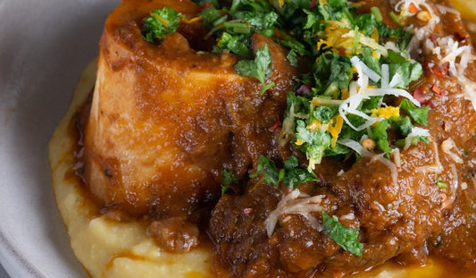 Kremowa polenta z gulaszem mięsnym ragù, posypana parmezanem i ziołami